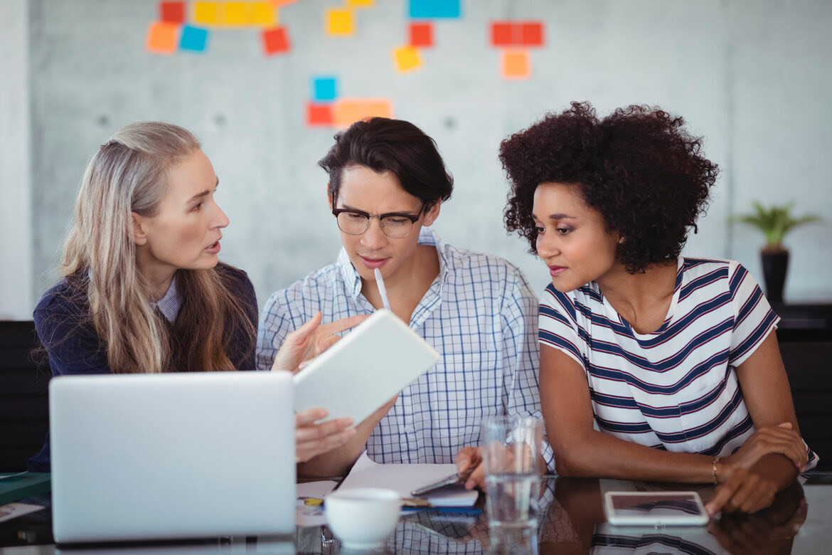 Three colleagues reviewing a document together